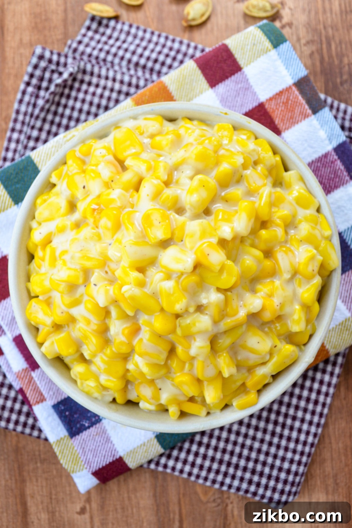 A bowl of creamy Instant Pot creamed corn resting on festive Fall-colored napkins, ready to be served.