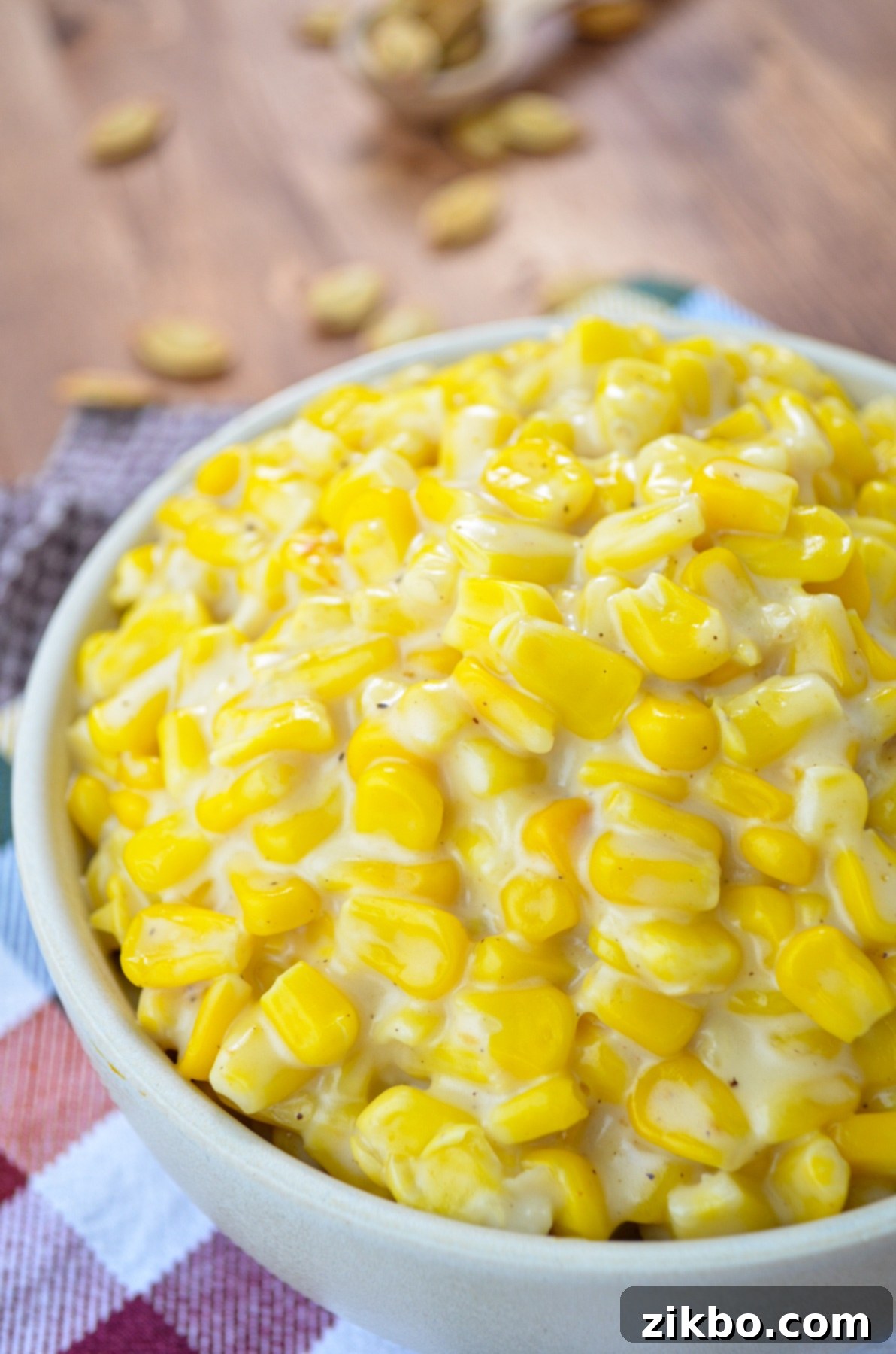 A serving bowl of creamy Instant Pot creamed corn, set on vibrant, multi-colored napkins, emphasizing its appeal as a side dish.