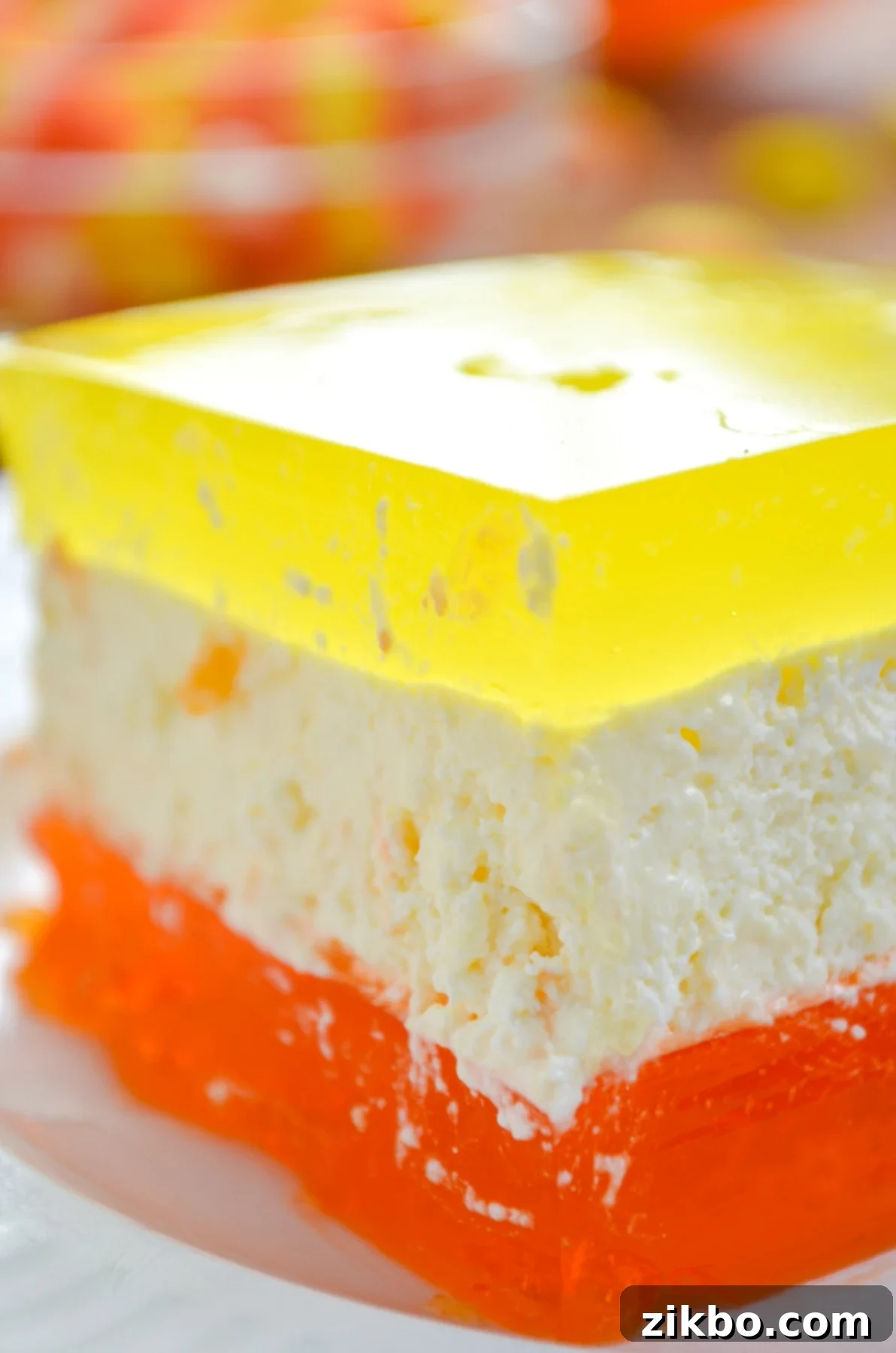 Halloween layered Jell-O with a distinct orange layer, a creamy cheesecake layer, and a bright lemon layer.
