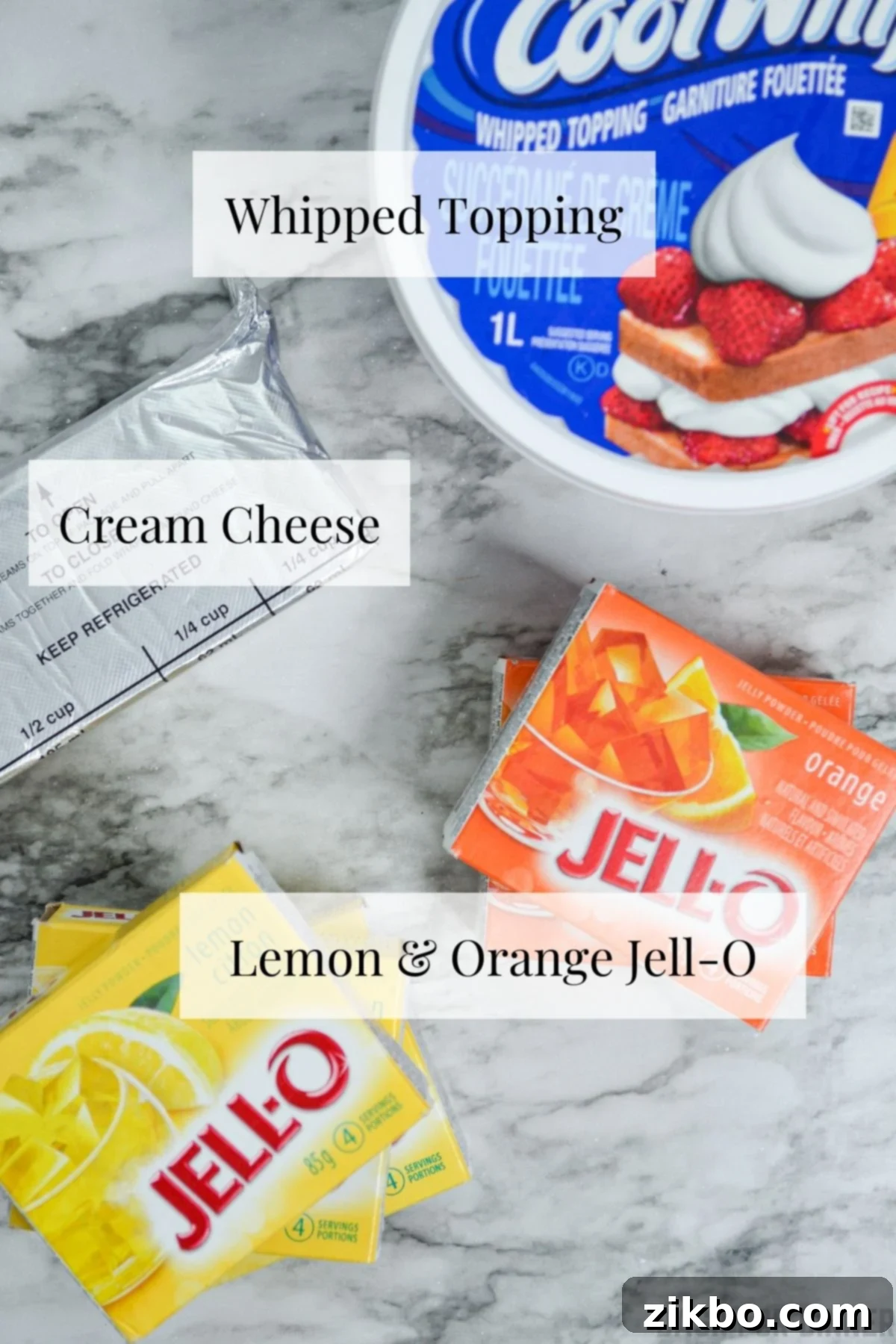 The essential ingredients laid out neatly to make layered Halloween Jell-O: Jell-O boxes, cream cheese, and Cool Whip.