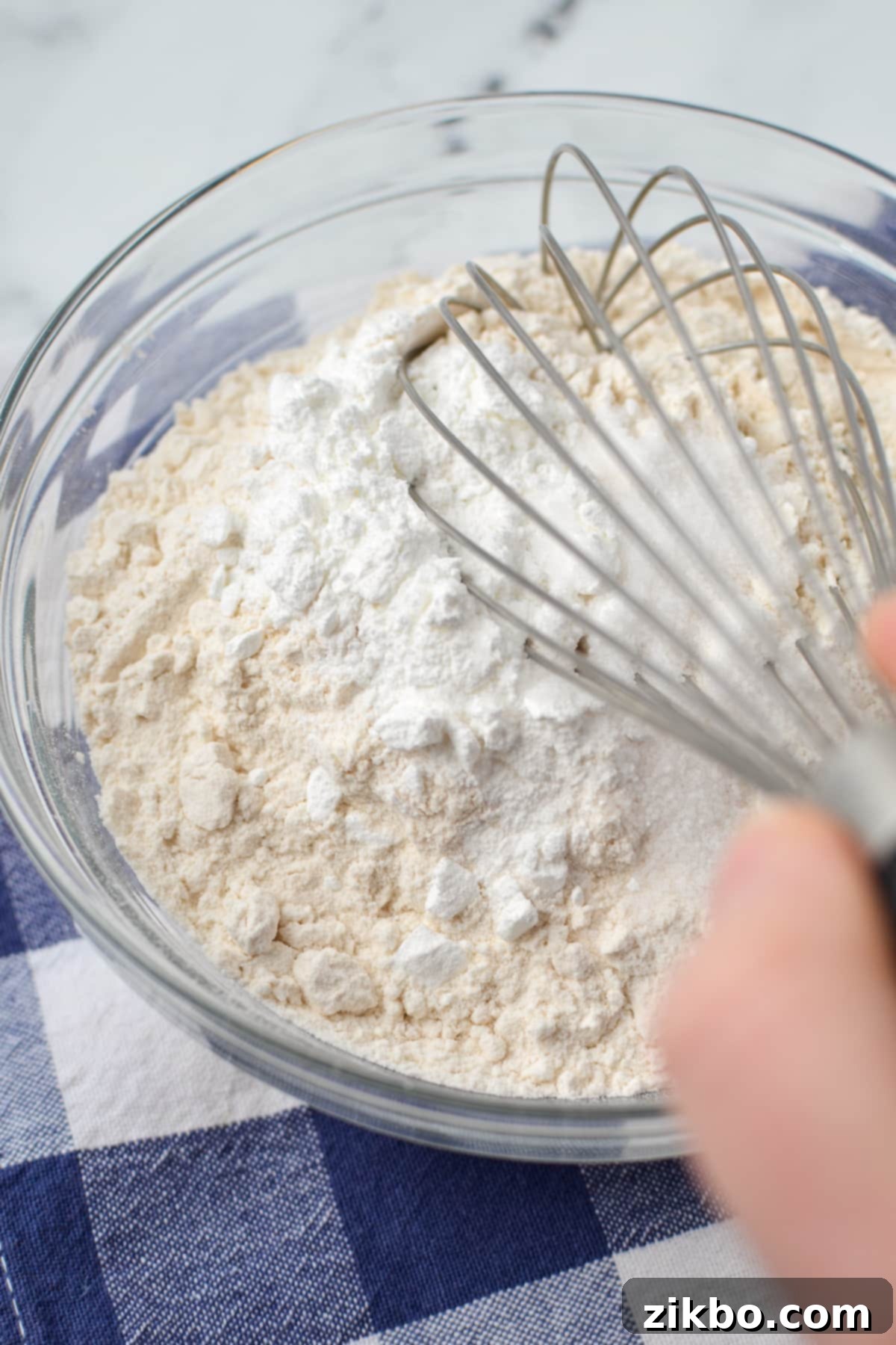 Whisking together all-purpose flour, baking powder, and salt in a bowl.