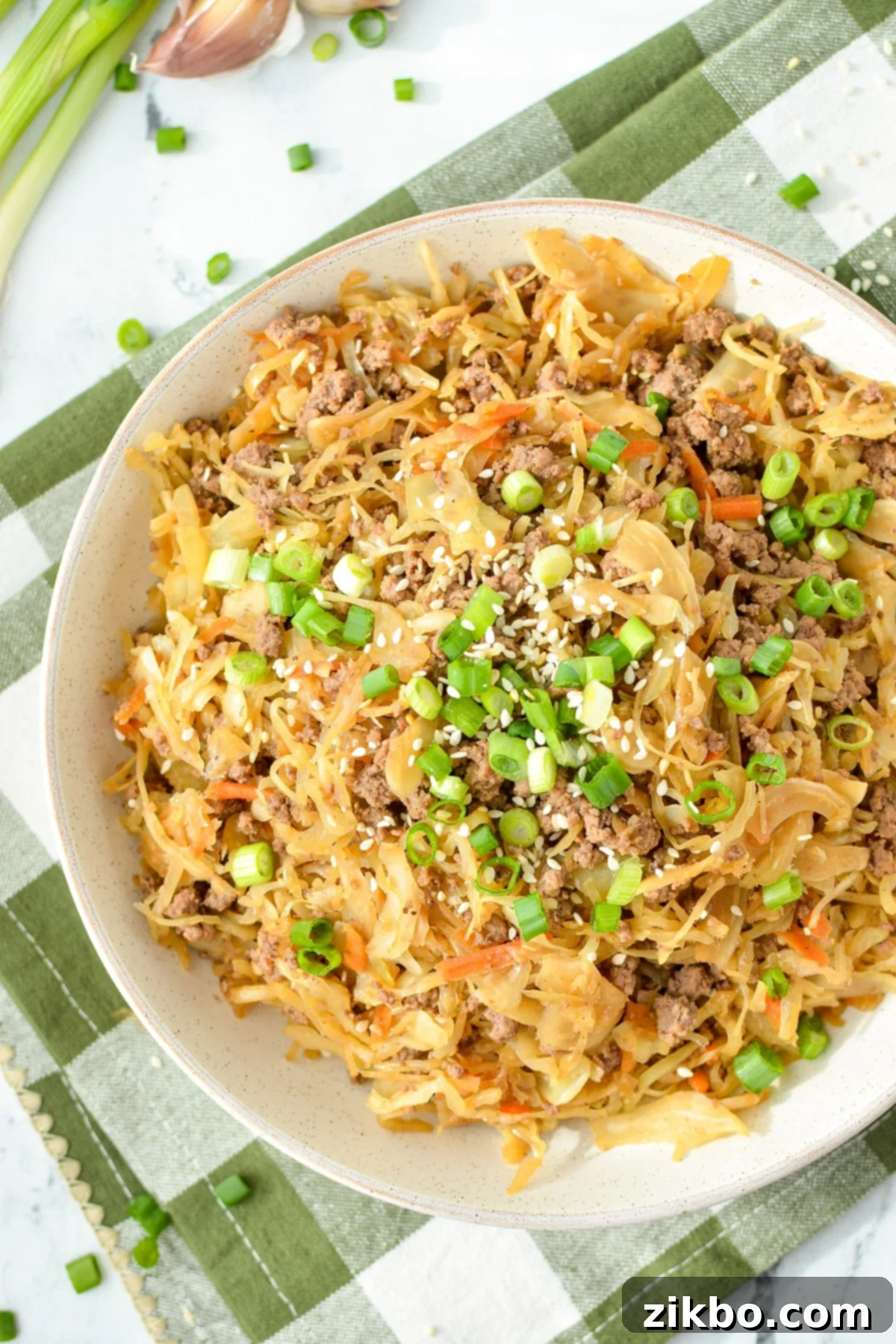 A vibrant bowl of Inside Out Egg Roll in a Bowl, topped with green onions and sesame seeds, ready for a healthy meal.
