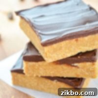 A stack of three no bake peanut butter bars, highlighting their layered goodness.