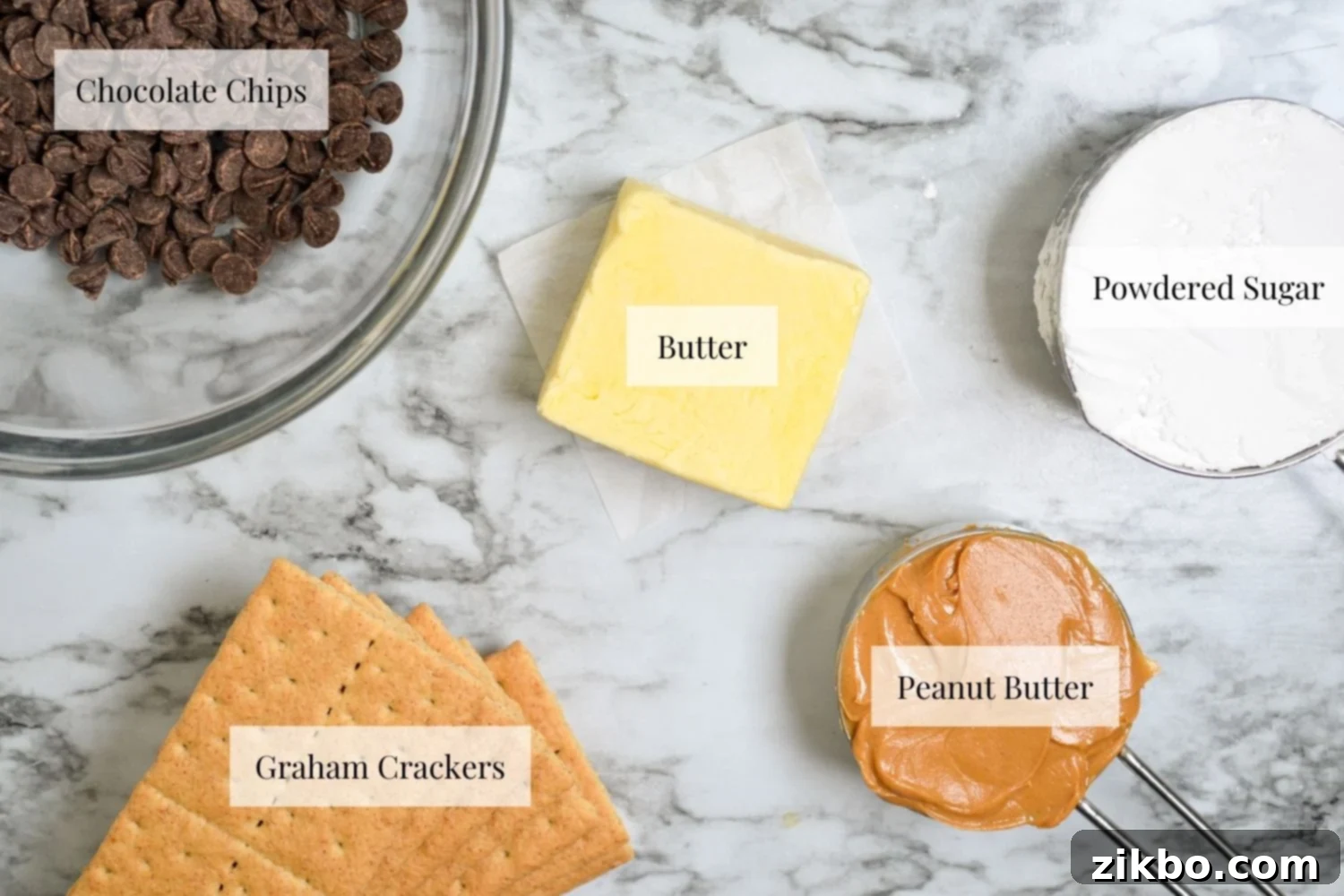 Ingredients needed to make no bake peanut butter bars: graham crackers, peanut butter, butter, powdered sugar, and chocolate chips laid out on a table.