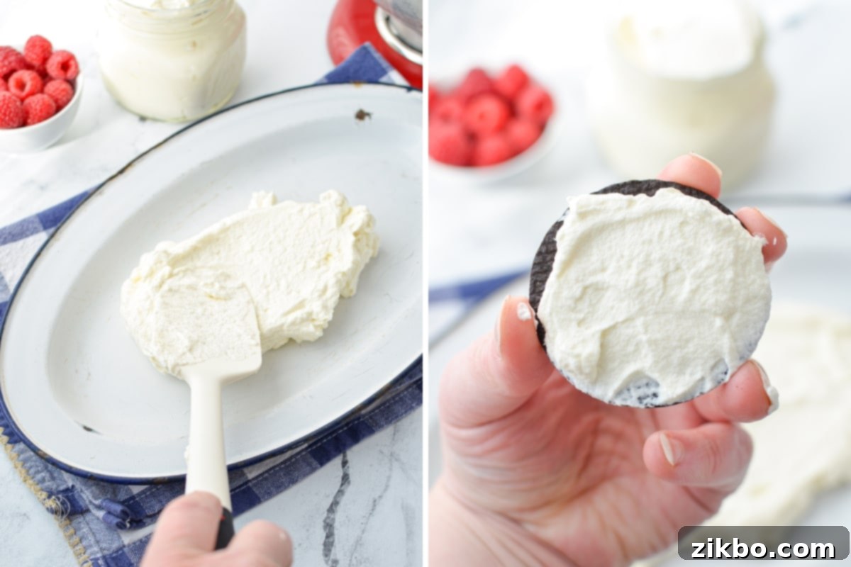 A chocolate wafer cookie being spread with a heaping tablespoon of homemade whipped cream, ready for assembly.