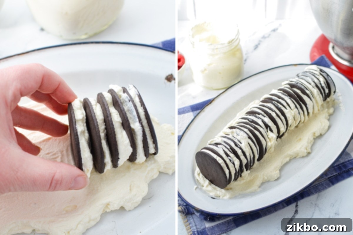 Layered chocolate wafer cookies and whipped cream forming a long log on a serving platter, ready to be fully covered.
