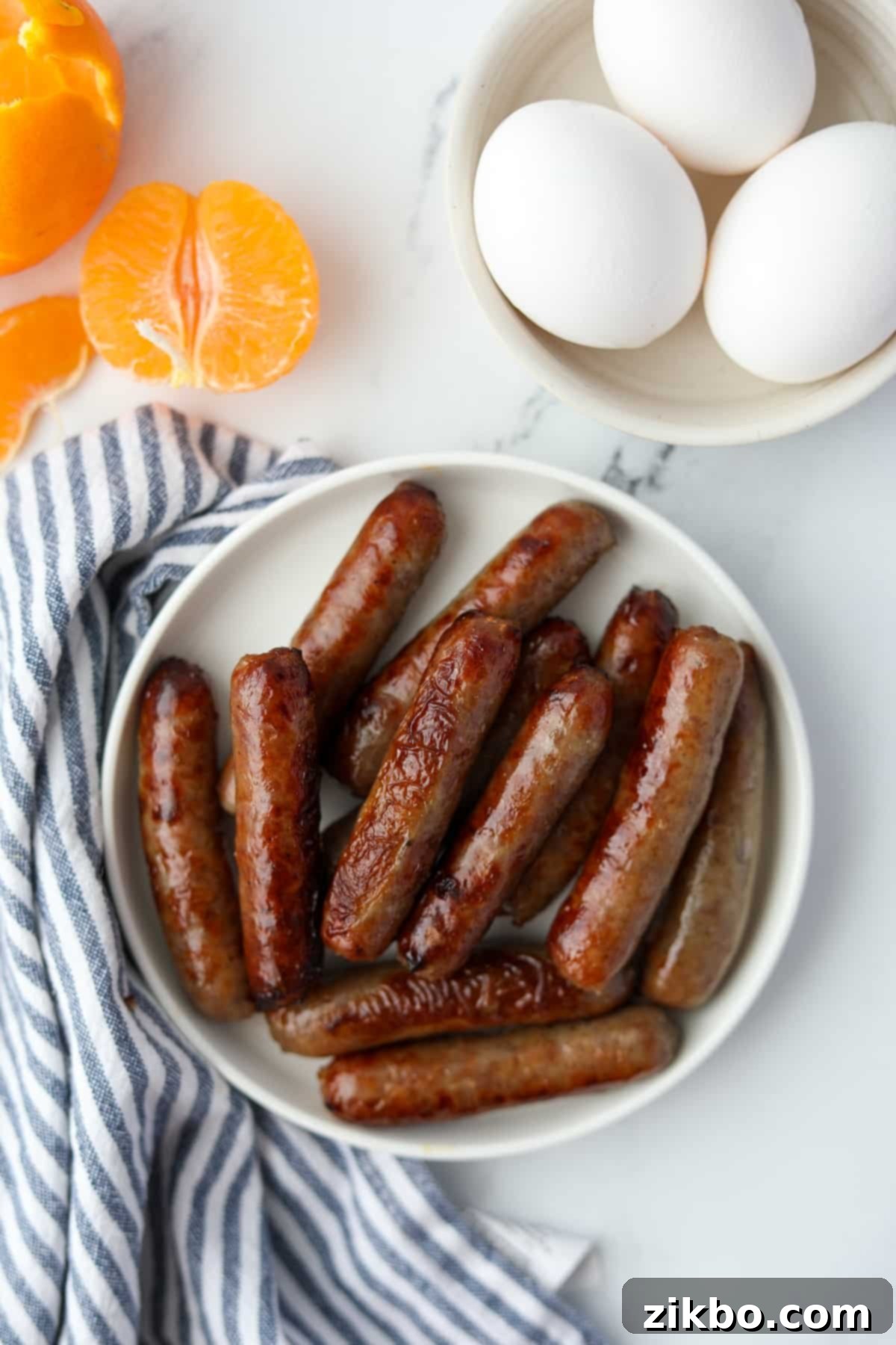 A plate of perfectly cooked breakfast sausages on a marble counter, ready to serve.