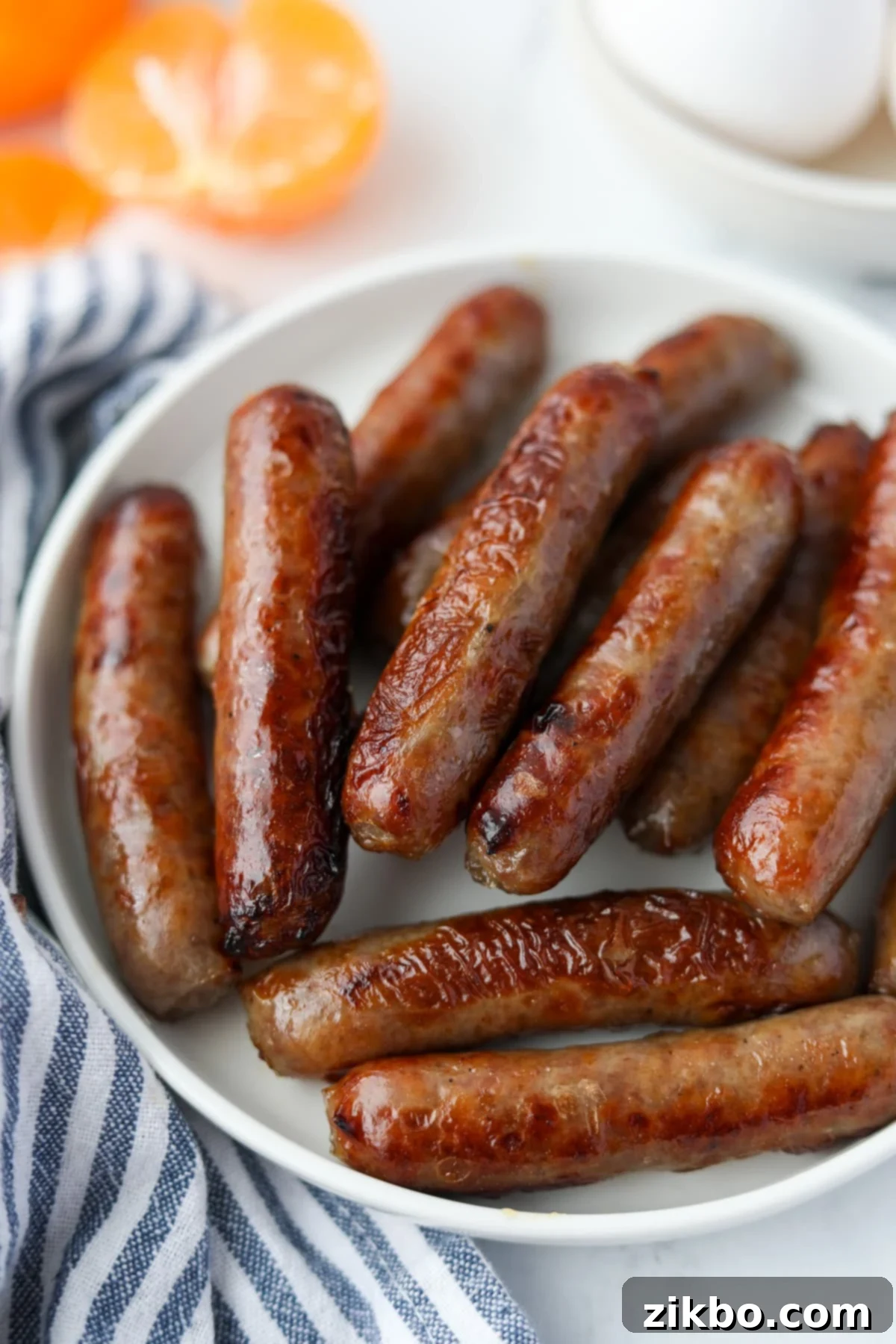 A plate of cooked breakfast sausages, golden brown and ready to eat.