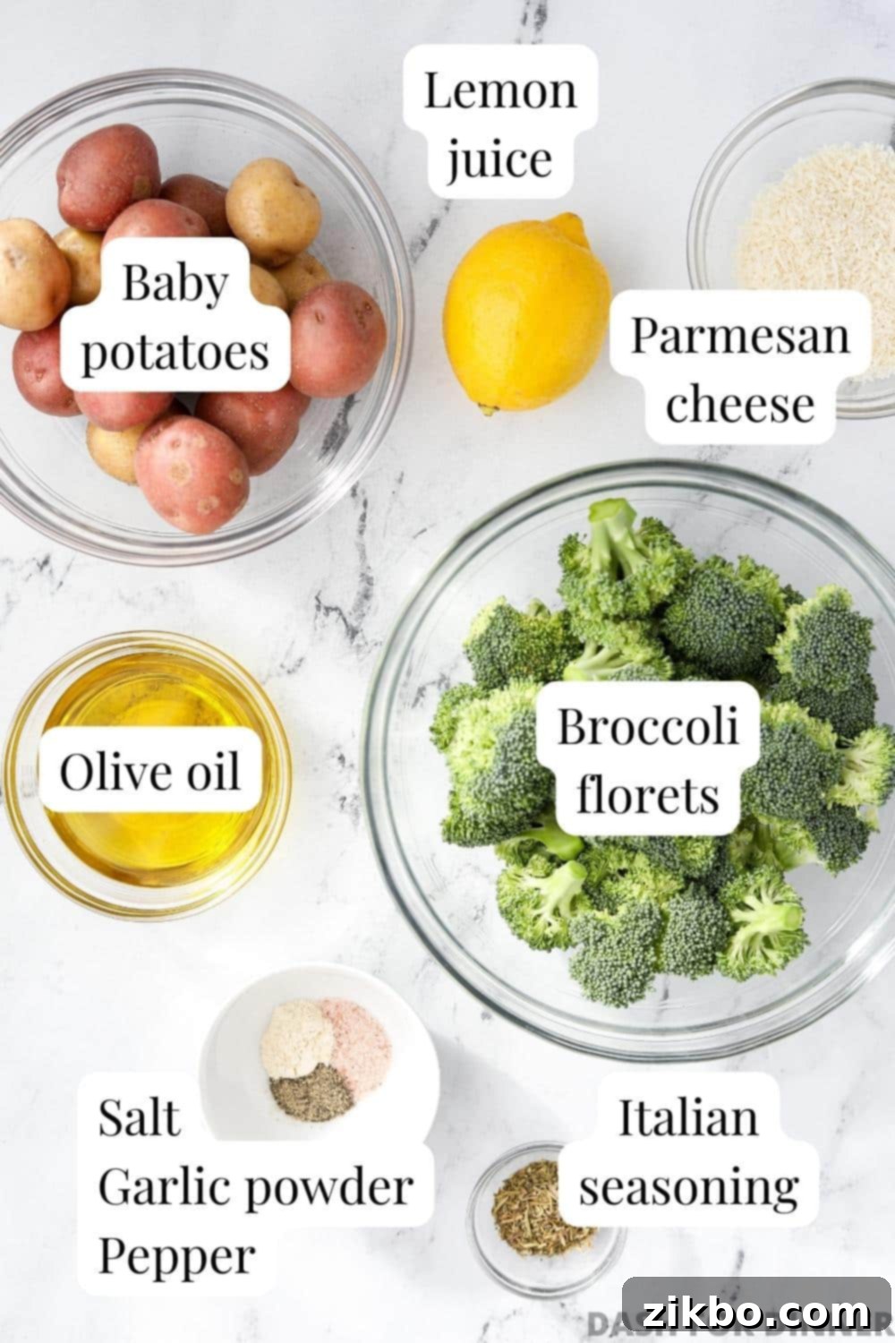 Crispy Roasted Broccoli and Potatoes 3 The ingredients needed to make roasted broccoli and potatoes, including fresh broccoli, baby potatoes, olive oil, a lemon, various seasonings, and a wedge of parmesan cheese.