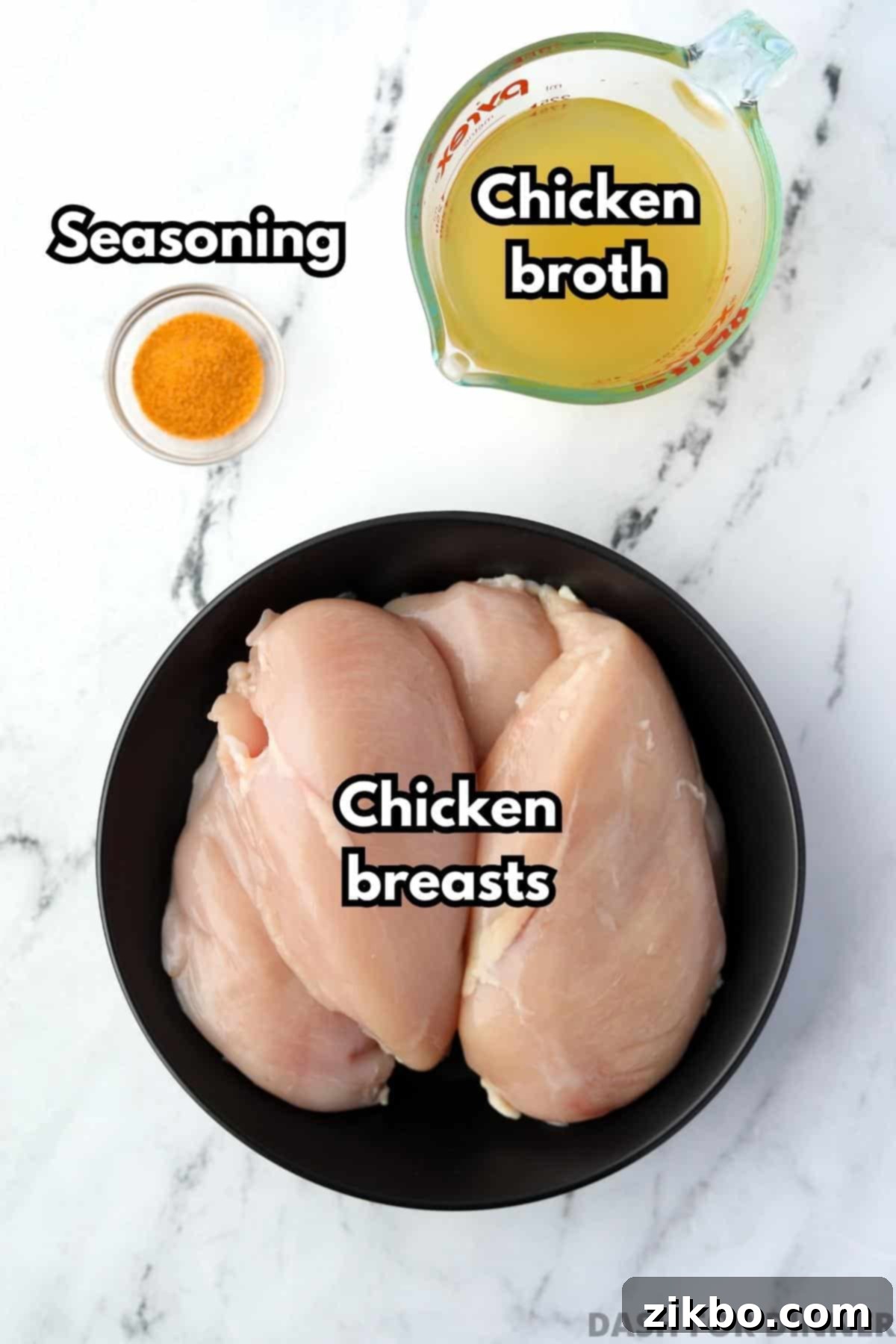 A plate with four chicken breasts, a small measuring cup of chicken broth, and some seasoned salt.