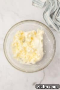 A bowl with softened cream cheese.