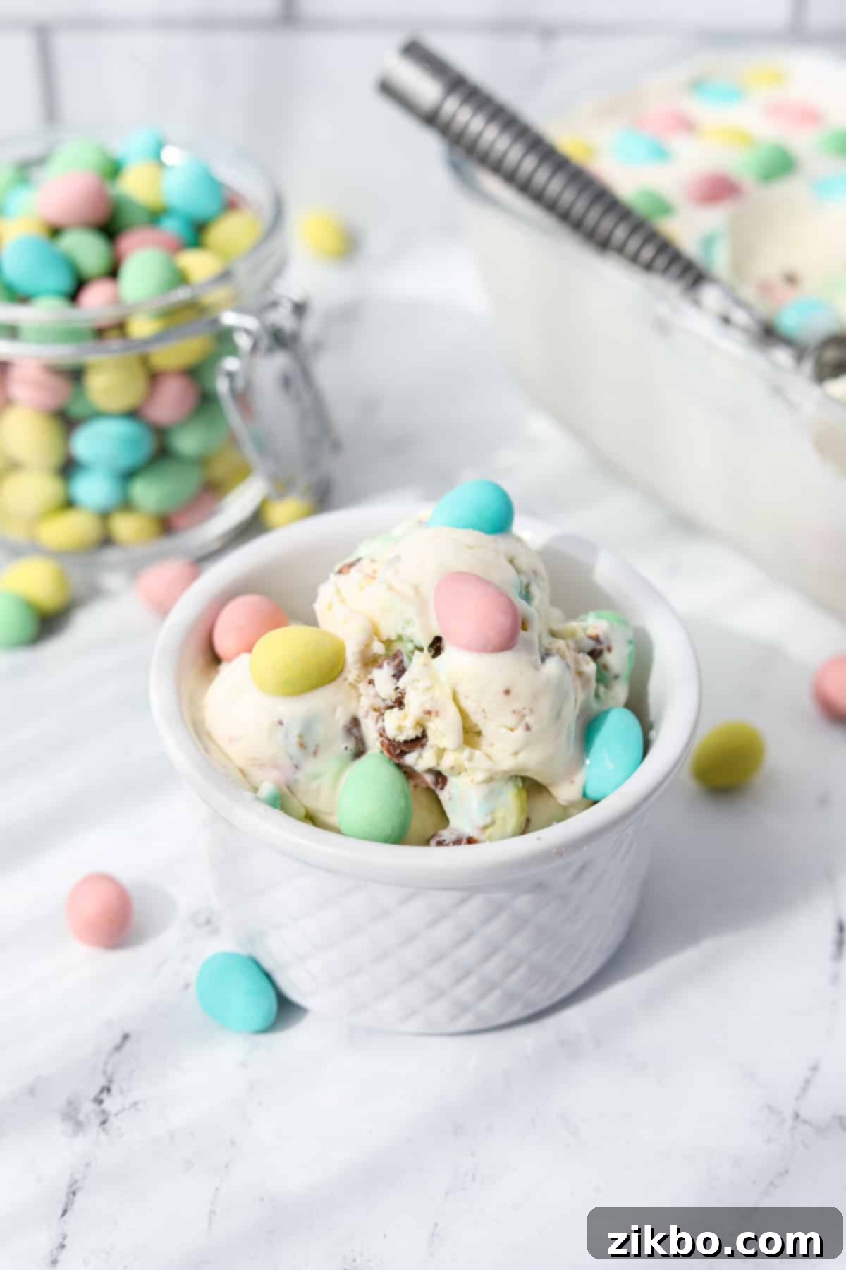 Pastel Egg Crunch Ice Cream 2 A vibrant bowl of homemade Mini Egg Ice Cream, adorned with colorful Cadbury Mini Eggs, signaling the joy of Easter.