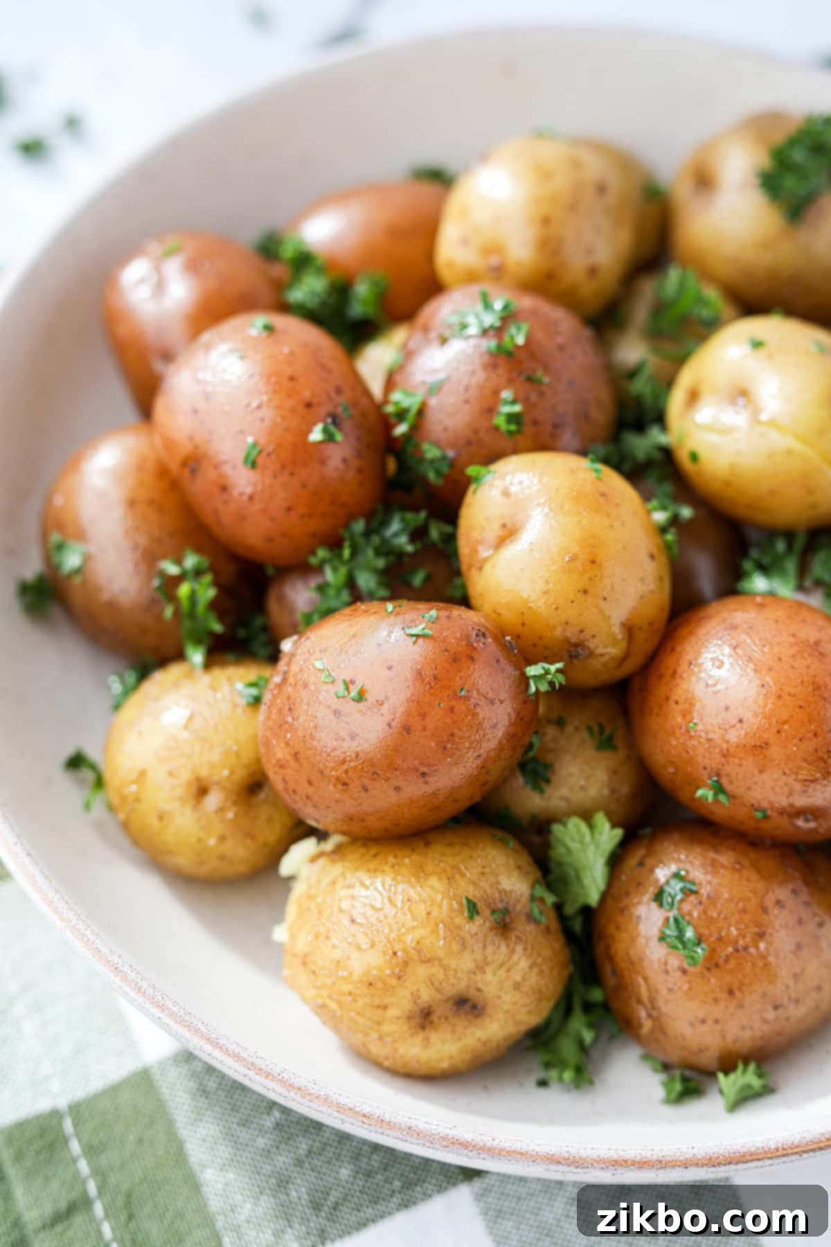 A bowl of steamed small potatoes garnished with parsley.