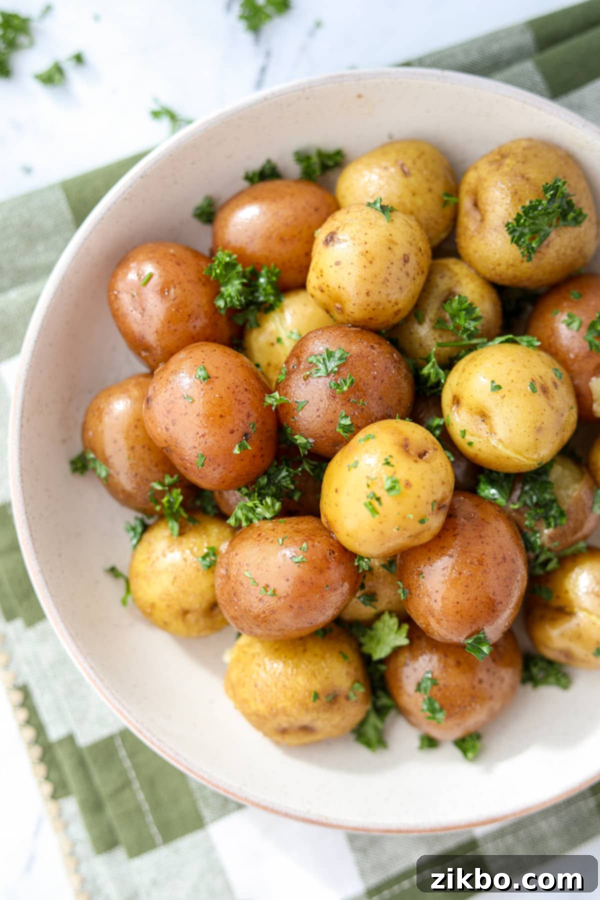 A bowl of new potatoes garnished with parsley.