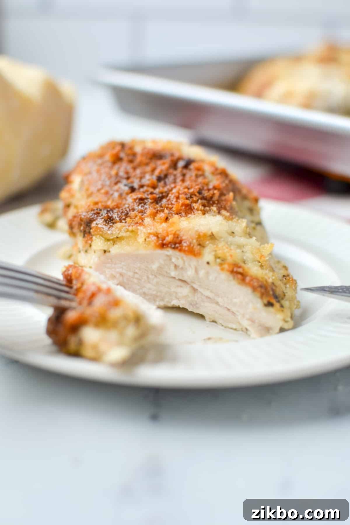 Creamy Parmesan Chicken 2 A perfectly baked, juicy mayo parmesan chicken breast that has been sliced into, revealing its tender interior.
