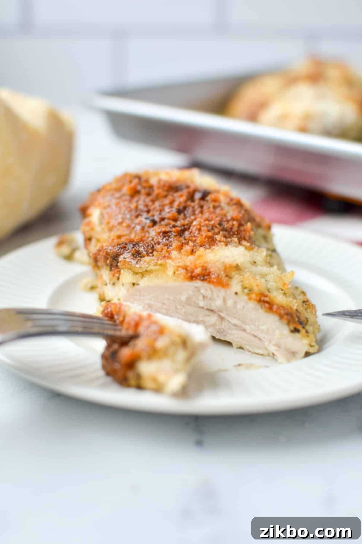 Creamy Parmesan Chicken 8 A close-up of a perfectly cooked mayo parmesan chicken breast, cut into, showcasing its tender, juicy interior and golden crust.