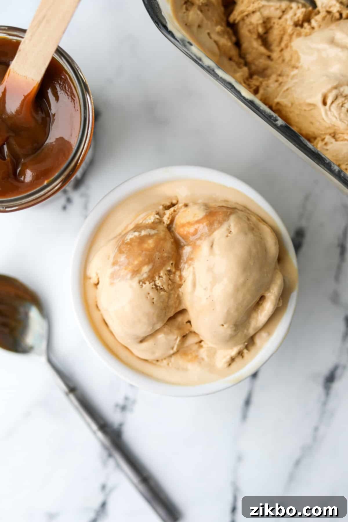 Decadent Dulce de Leche Ice Cream 2 Several scoops of dulce de leche ice cream in a bowl, garnished with a drizzle of caramel.