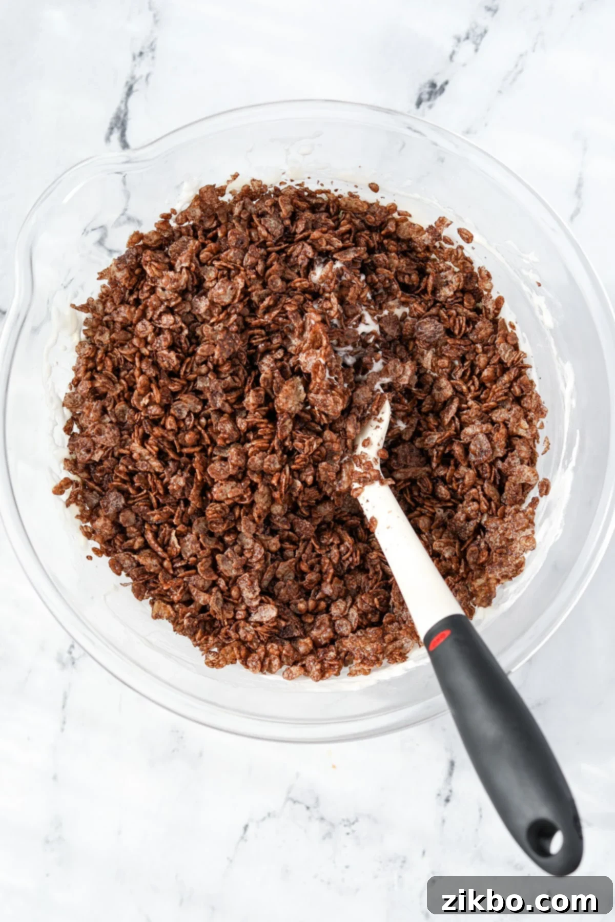 A bowl with crispy cocoa rice added to melted marshmallows.