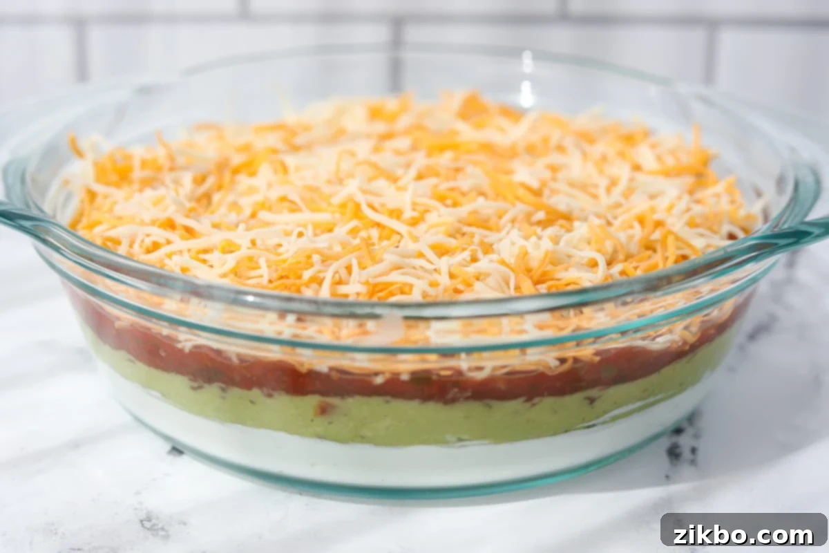 A glass baking dish with a layered dip inside, ready to serve.