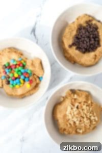 Three bowls of cookie dough, with three different mix-ins: chocolate chips, M&Ms, and peanuts.