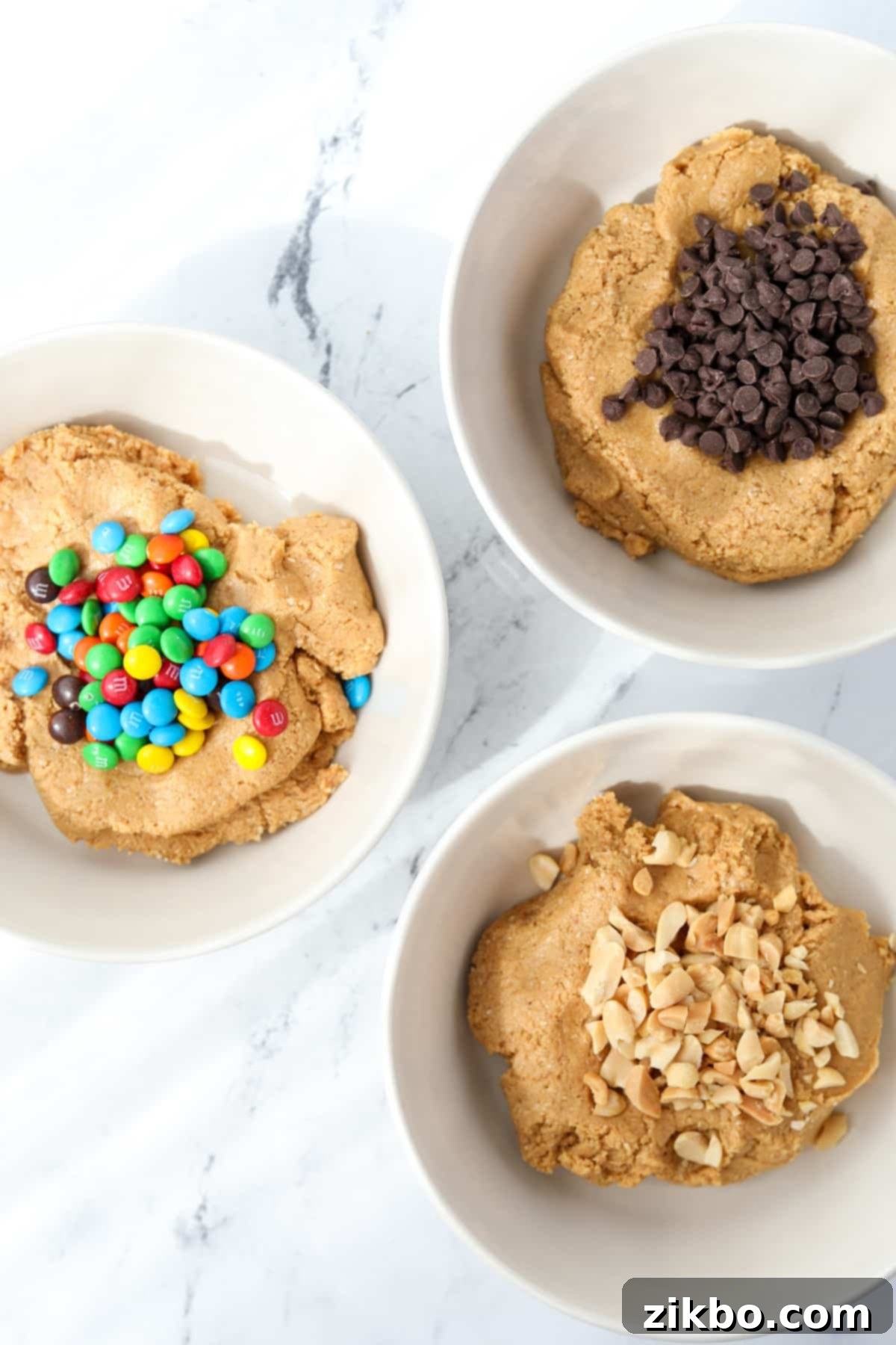 Protein Cookie Dough 6 Adding mini chocolate chips to the protein cookie dough in a mixing bowl.