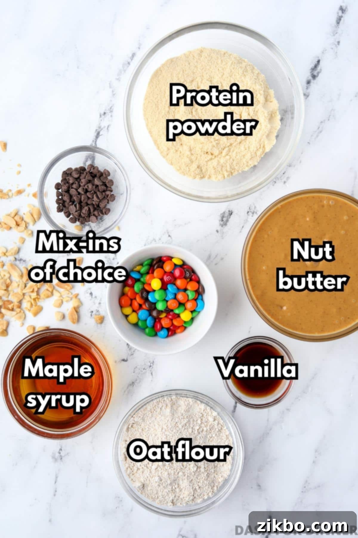 The ingredients needed to make protein balls: nut butter, protein powder, maple syrup, oat flour, vanilla, min-ins.
