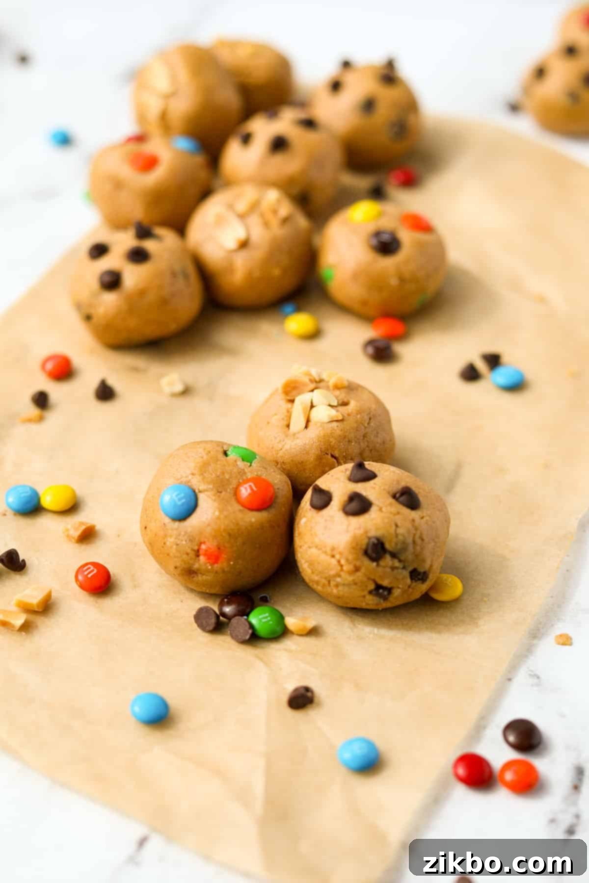 Three protein cookie dough balls in the center, with others on the sidelines.