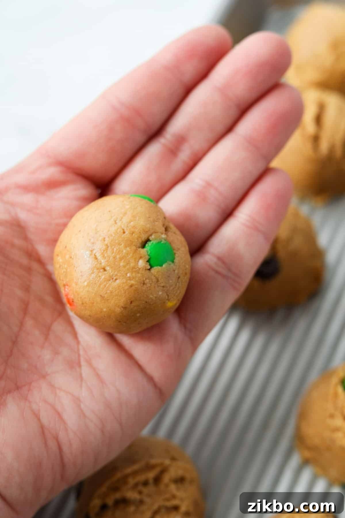 Rolling cookie dough into a smooth ball.