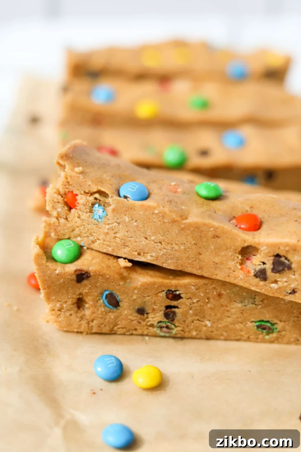 Protein-Packed Monster Cookie Bars 11 Two Monster Cookie Protein Bars stacked on top of each other, showing the chewy texture and colorful inclusions.
