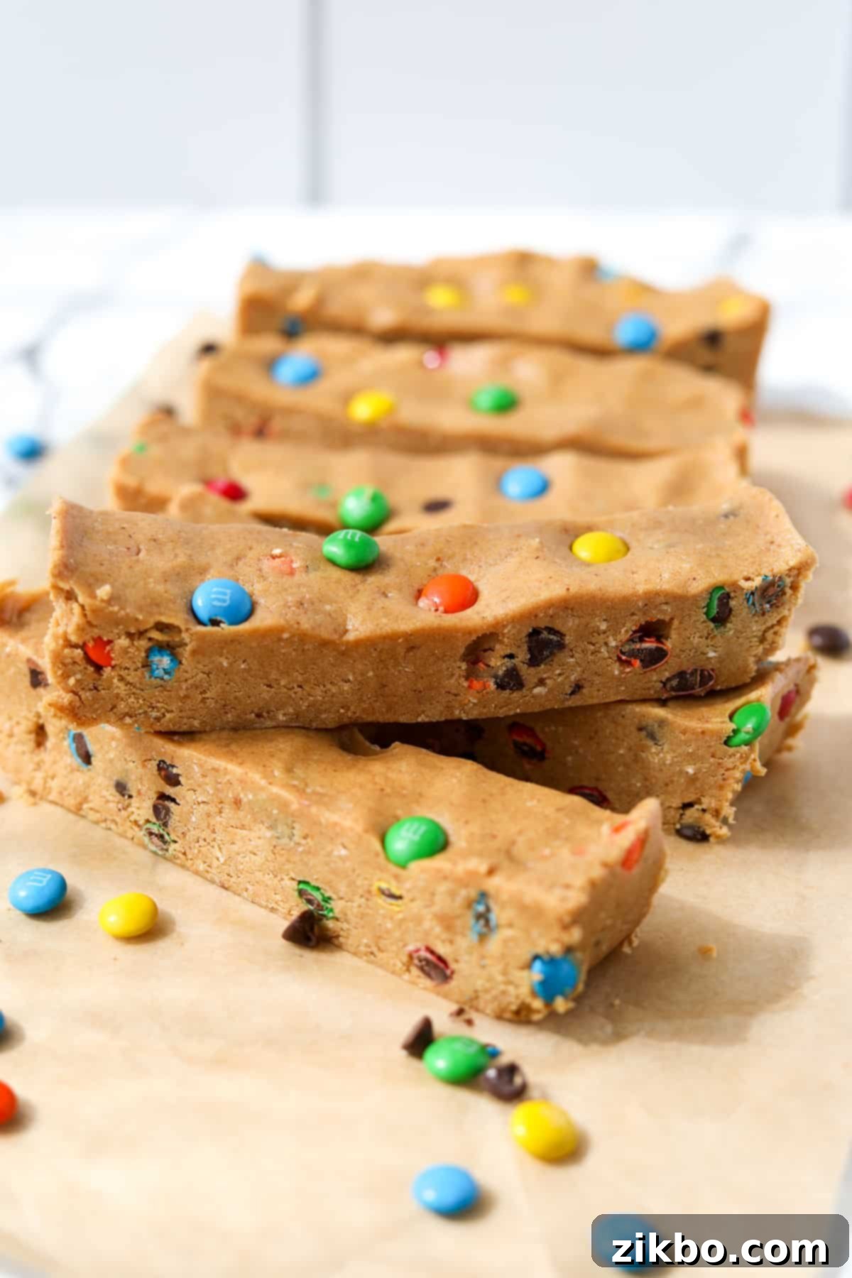 Protein-Packed Monster Cookie Bars 12 Protein bars layered on a sheet of parchment paper, highlighting their delicious texture and colorful toppings.