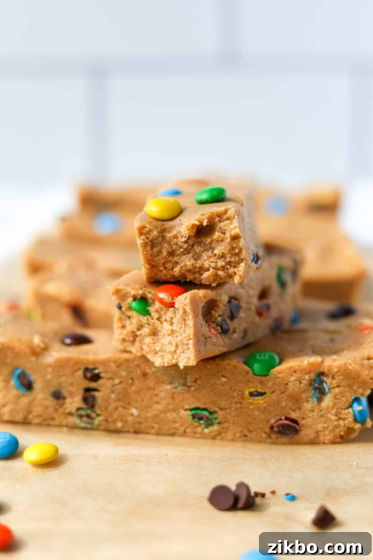 Protein-Packed Monster Cookie Bars 13 Protein bars stacked on top of each other, showing the soft, chewy center with M&M's and chocolate chips.