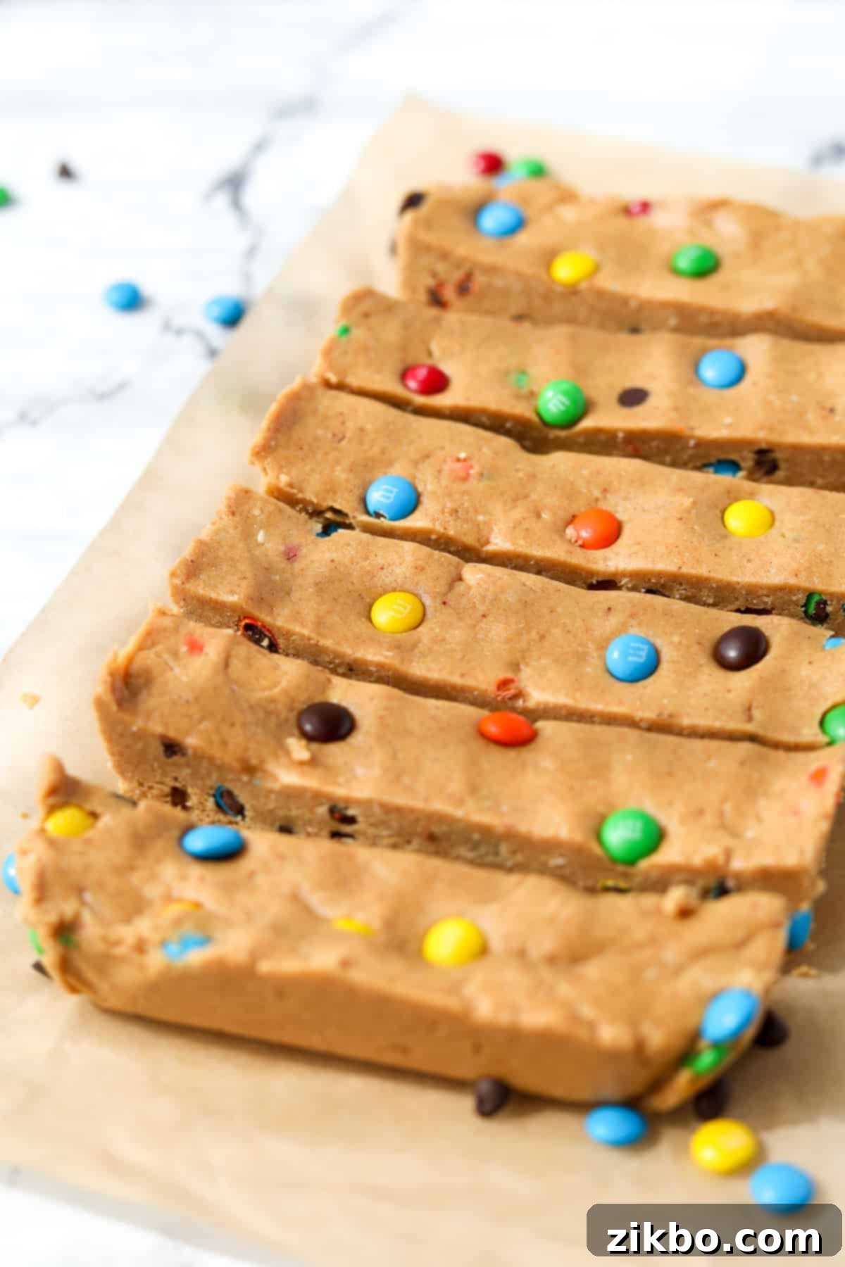 Protein-Packed Monster Cookie Bars 10 6 homemade protein bars neatly sliced and arranged on a sheet of parchment paper, ready to be enjoyed.