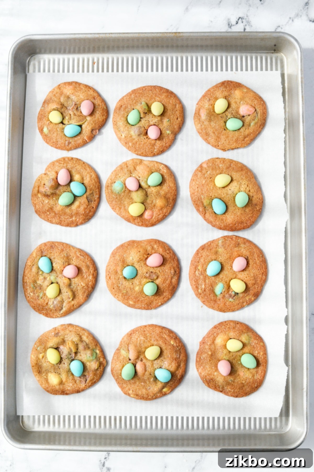 A baking sheet with mini egg cookies on it.
