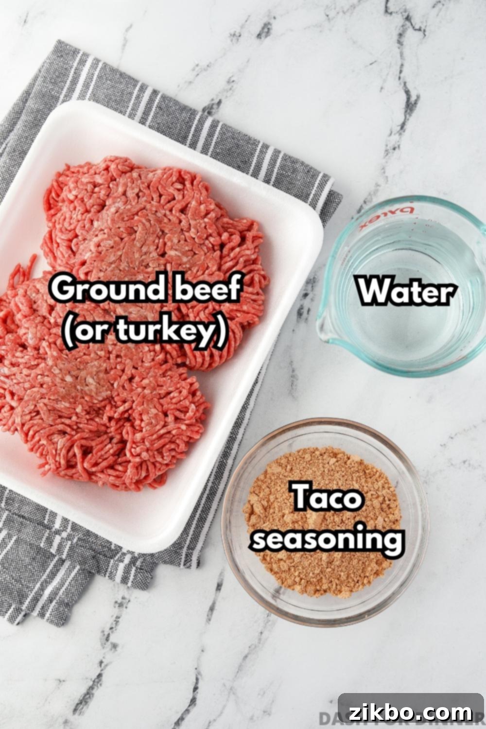 A package of ground beef, with a small bowl of water and a bowl of taco seasoning, demonstrating the simple ingredients required.