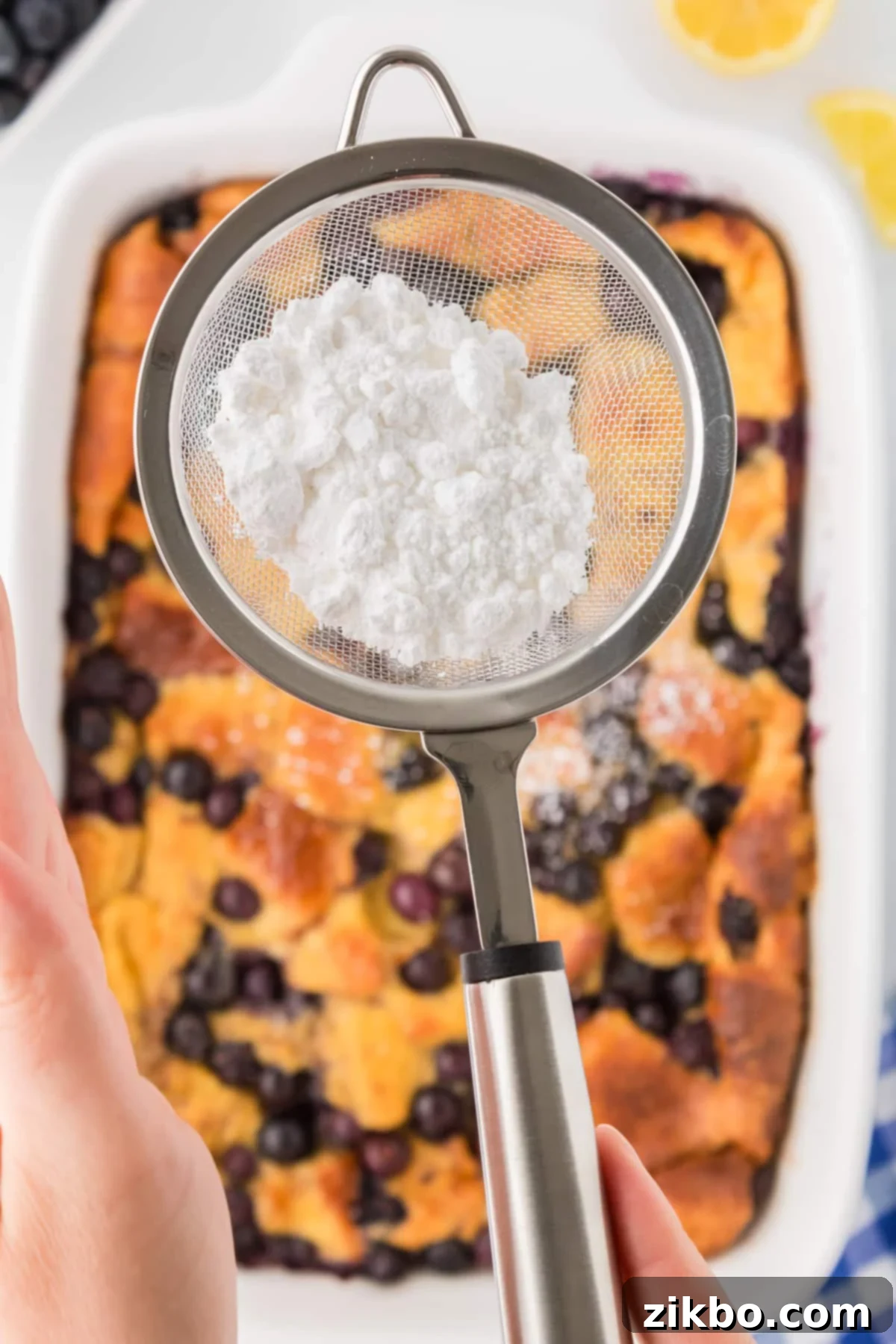 Overnight Brioche French Toast Bake 11 Using a sifter to top French toast with powdered sugar.
