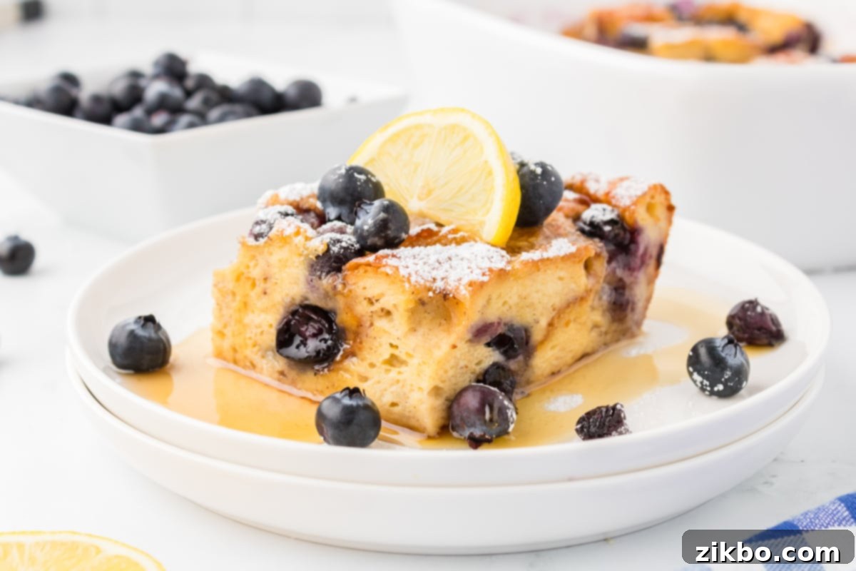 Overnight Brioche French Toast Bake 16 A square of baked French toast garnished with lemon and blueberries.