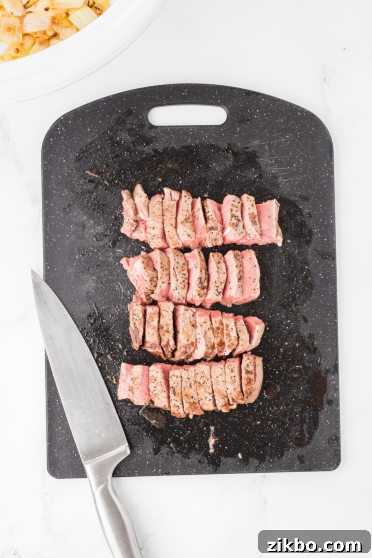 Slow Cooker Pepper Steak 6 A cutting board with beef cut into strips.