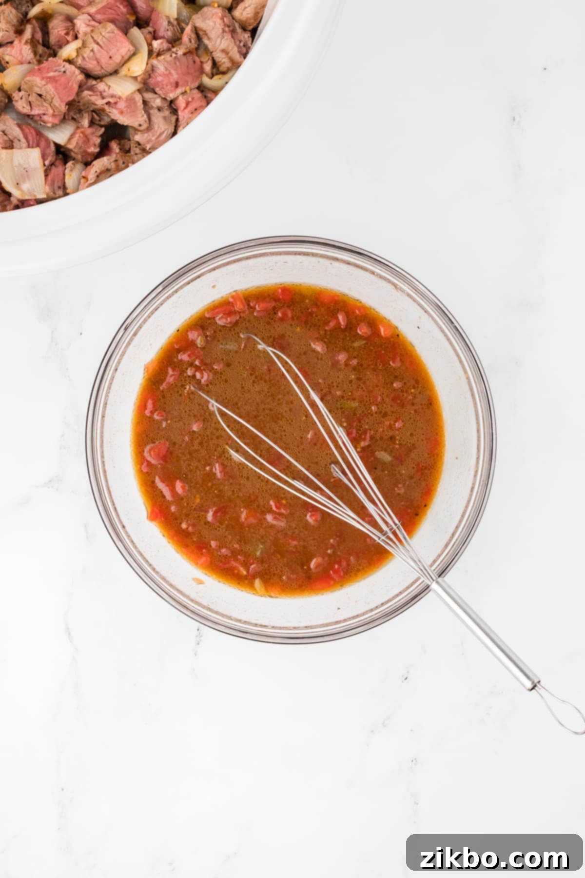 Slow Cooker Pepper Steak 8 A small bowl with a whisk and sauce ingredients being combined.