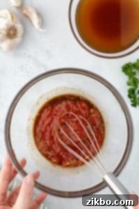 Whisking together ketchup and sauce ingredients.