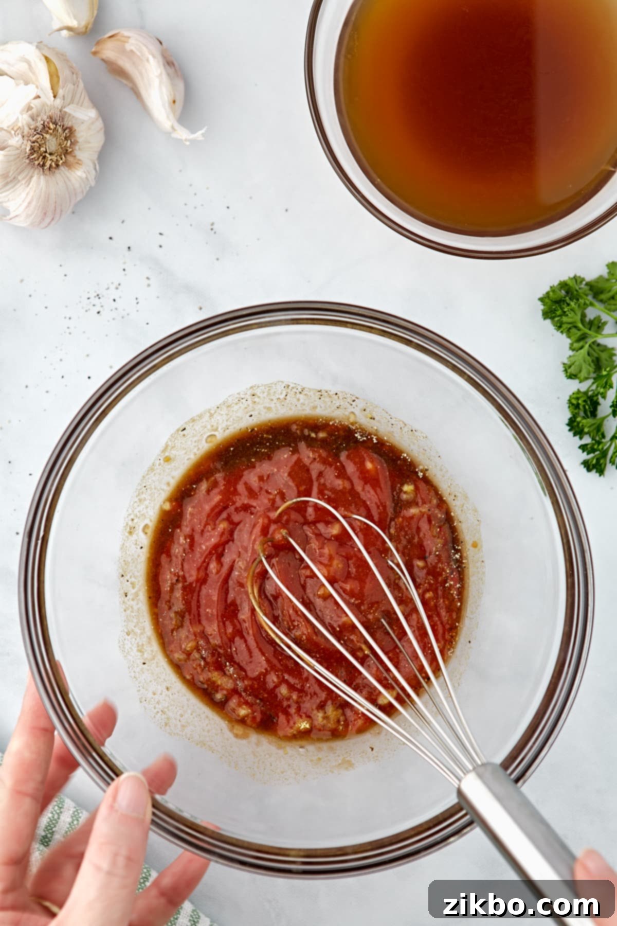 Whisking together ketchup and sauce ingredients.