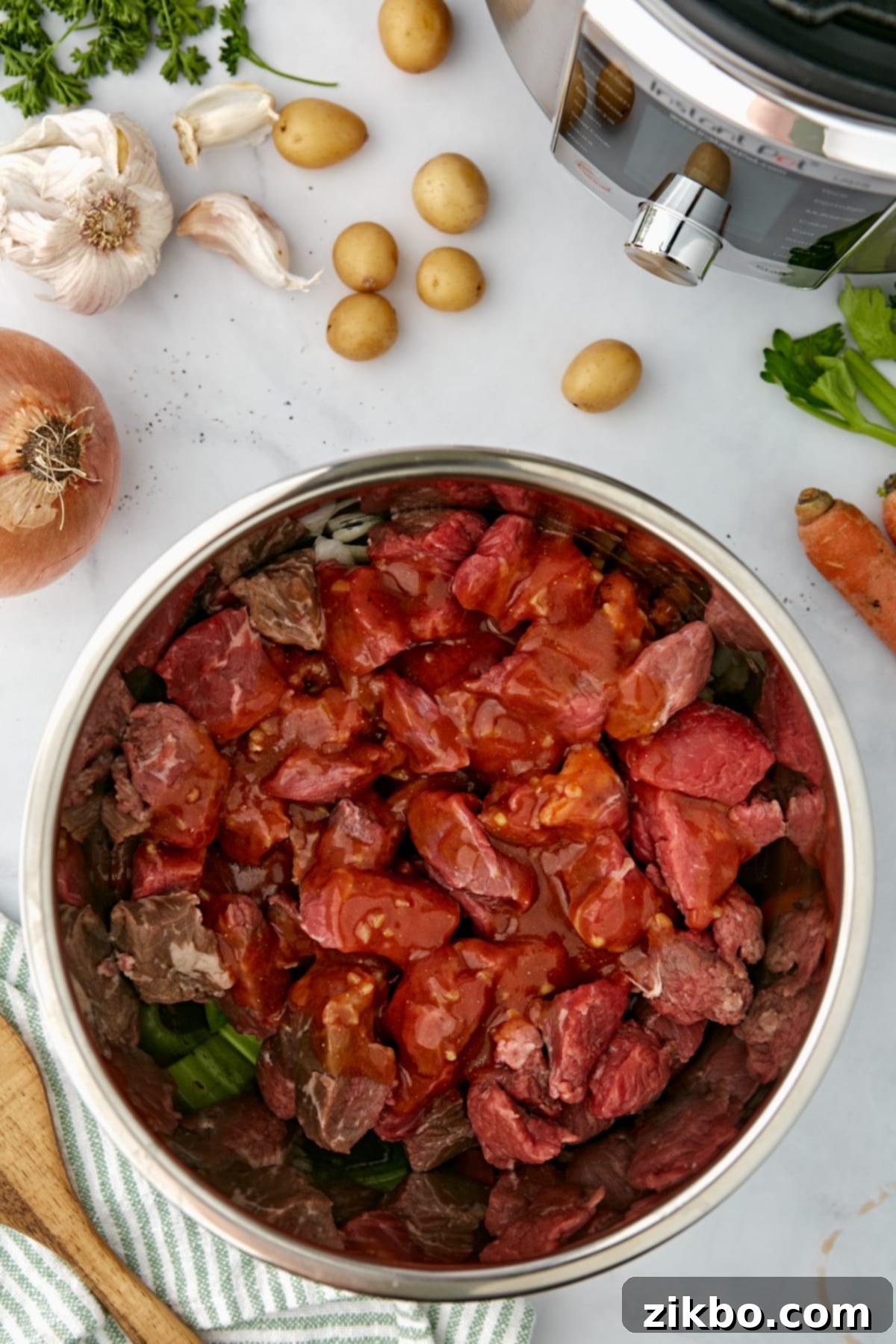 An Instant Pot filled with beef cubes and a sauce mixture.