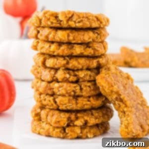 Spiced Pumpkin No-Bake Bites 14 A stack of golden-orange pumpkin no-bake cookies, with one cookie showing a bite taken out, revealing its rich texture.