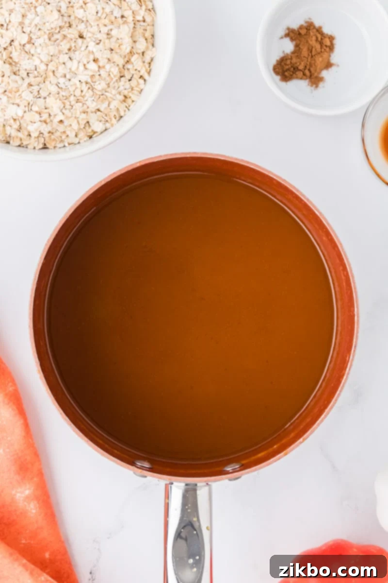 Spiced Pumpkin No-Bake Bites 5 A saucepan filled with a simmering, orange-colored mixture, indicating it has reached a boil.