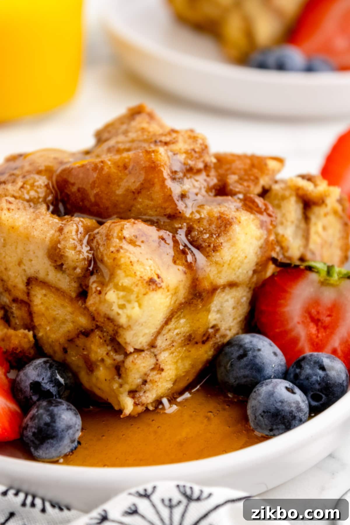 Golden French toast casserole in a slow cooker, cooked to perfection and drizzled with maple syrup.