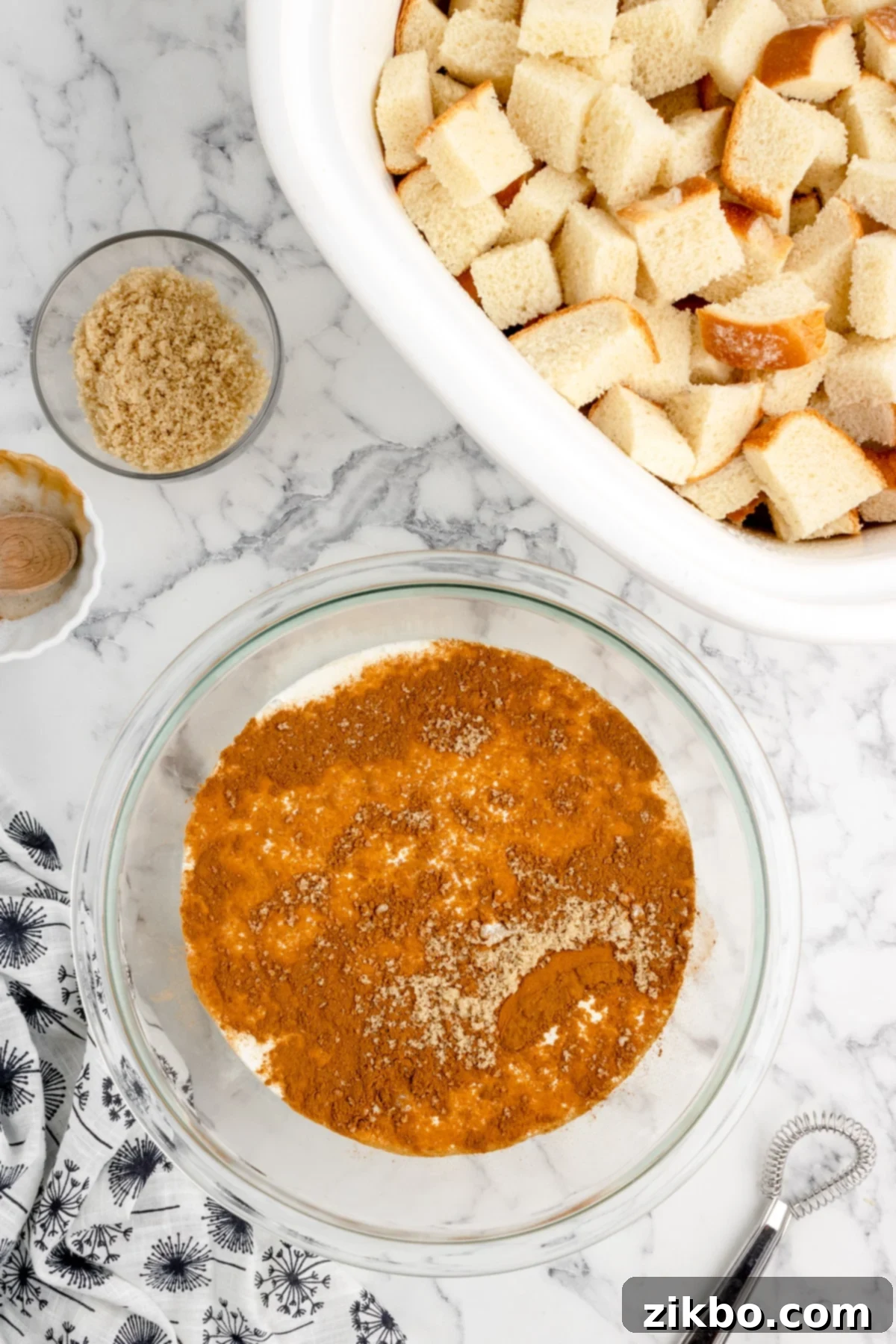 A bowl filled with a perfectly smooth custard mixture, incorporating eggs, cinnamon, brown sugar, and half and half.