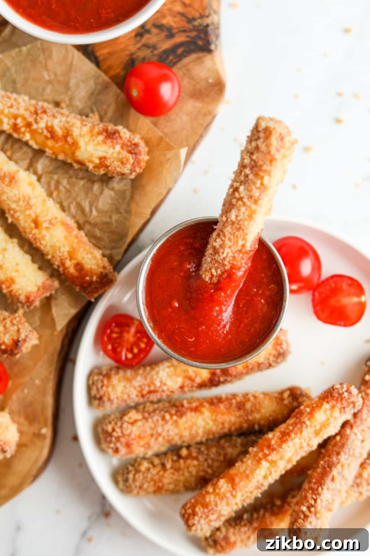 A hand dipping an air fried cheese fry into a bowl of rich pizza sauce, ready to be enjoyed.