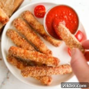 Dipping a breaded halloumi fry into pizza sauce, highlighting the deliciousness of air-fried halloumi.