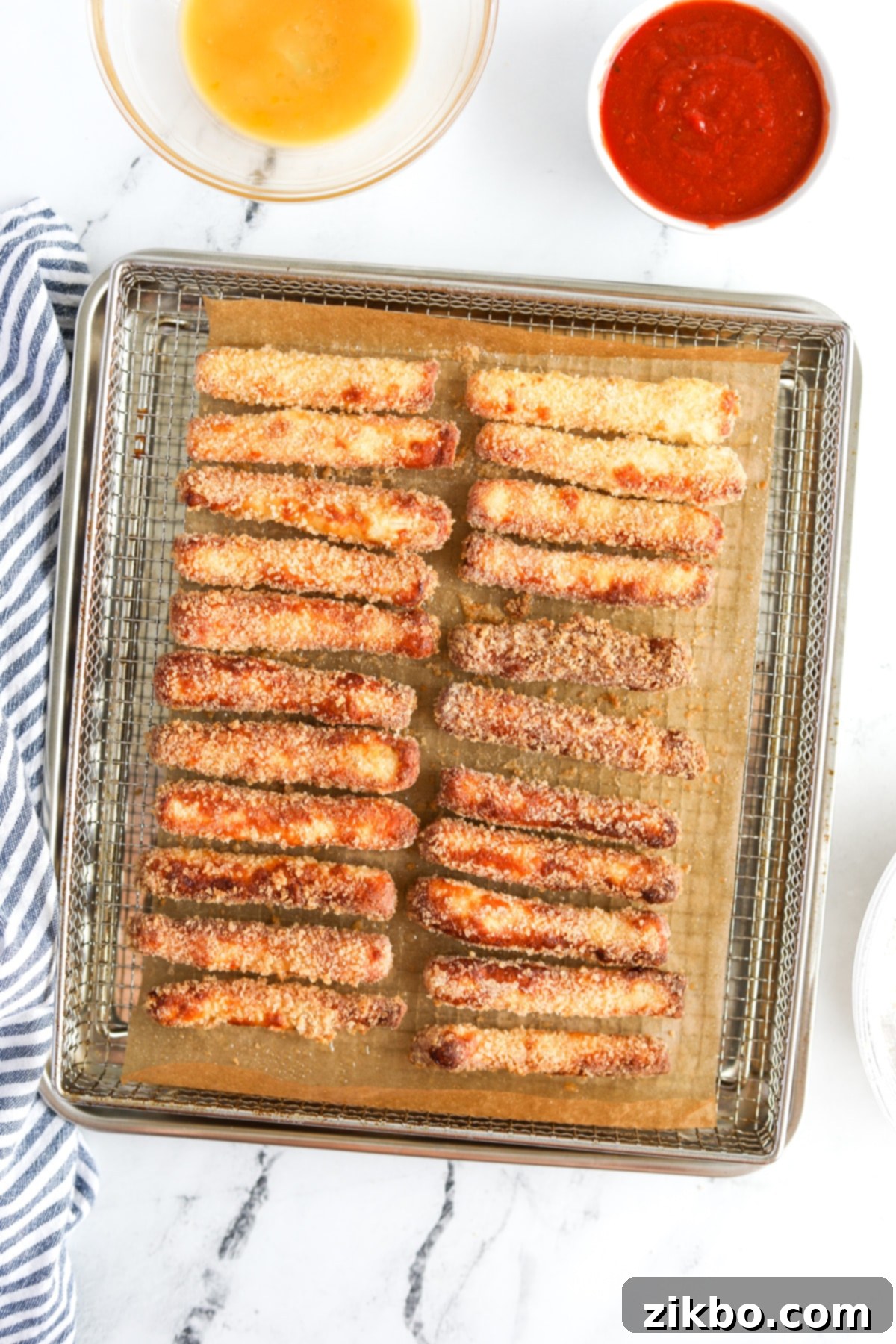An air fryer tray filled with perfectly golden and crispy halloumi fries, hot and ready to be served.