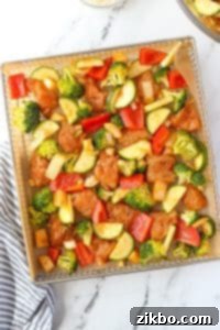 An air fryer tray filled with chicken and vegetables.