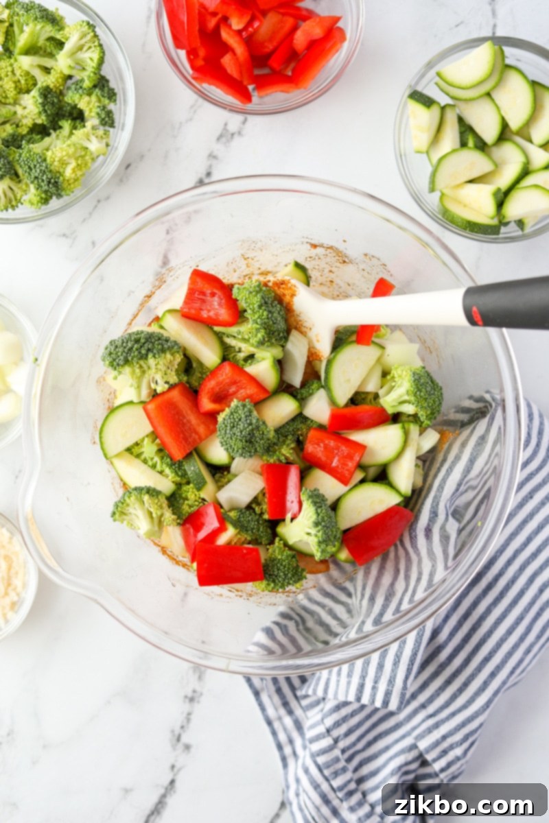 A bowl with broccoli, peppers, onions, and zucchini added to it.